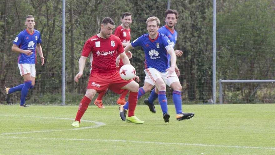 El jugador del Colunga Matías trata de hacerse con el balón, presionado por Edu Cortina.