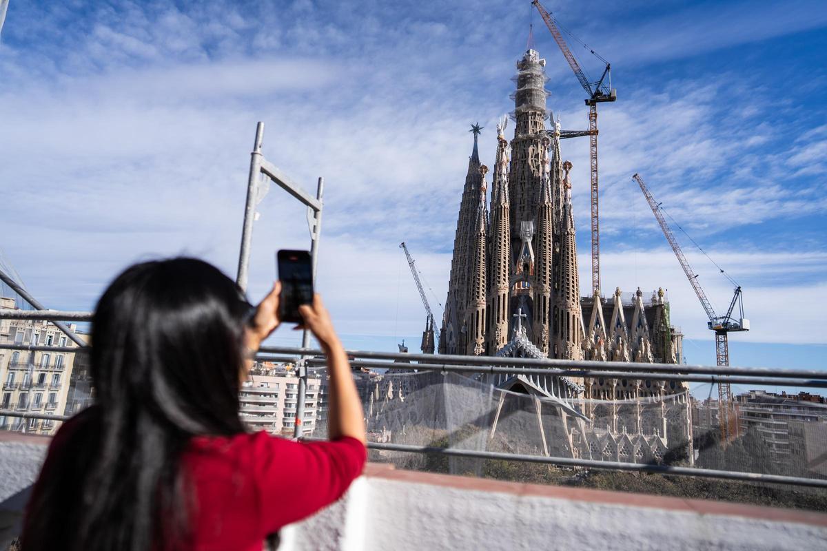 Xiao, vecina de la Sagrada Família, graba en video la colocación de la pieza desde su terraza.