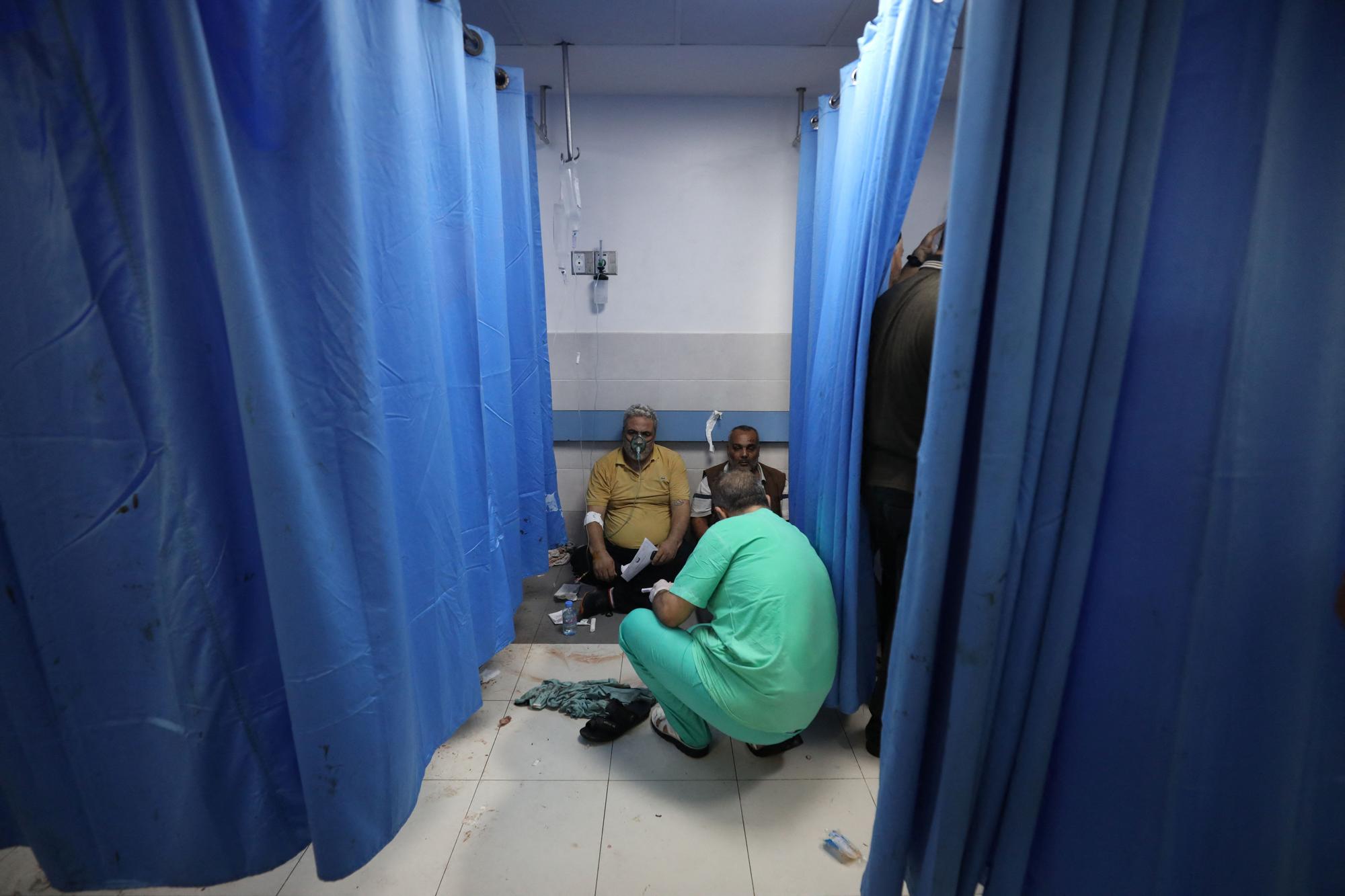 Injured people are assisted after Israeli air strike hit a hospital, according to Gaza Health Ministry