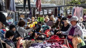 Varias personas mirando ropa en un mercadillo vintage en Barcelona.