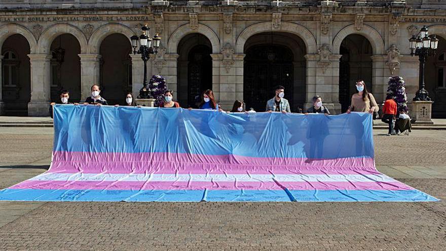 Activistas extienden la bandera trans en María Pita. |   // IRIA TATO BRITOS