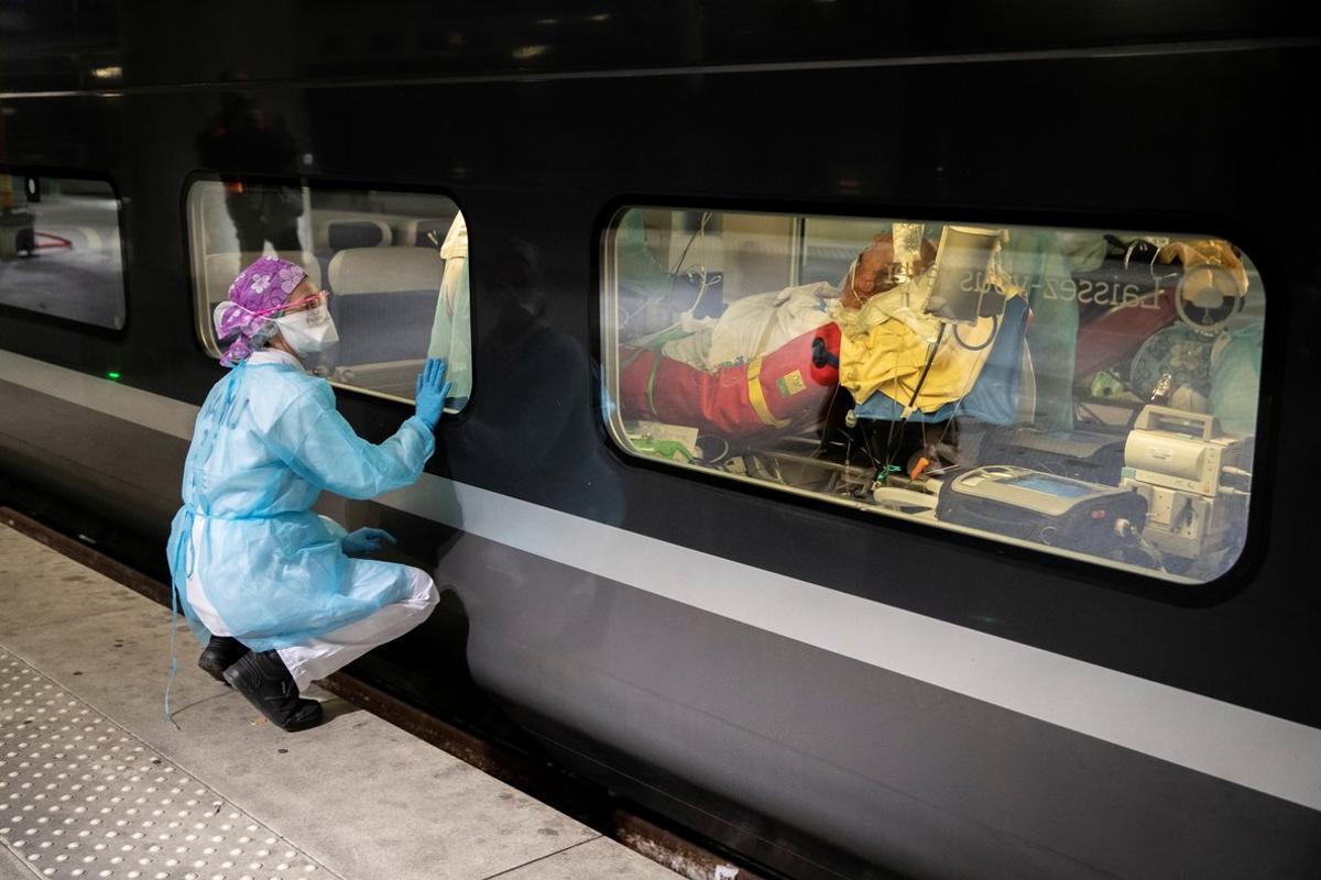 A medical staff looks through the window of a TGV high speed train before its departure to evacuate patients infected with the COVID-19 from Paris region hospitals to Brittany, as the spread of the coronavirus disease continues, in Paris, France April 1, 2020. Picture taken April 1, 2020. Thomas Samson/Pool via REUTERS