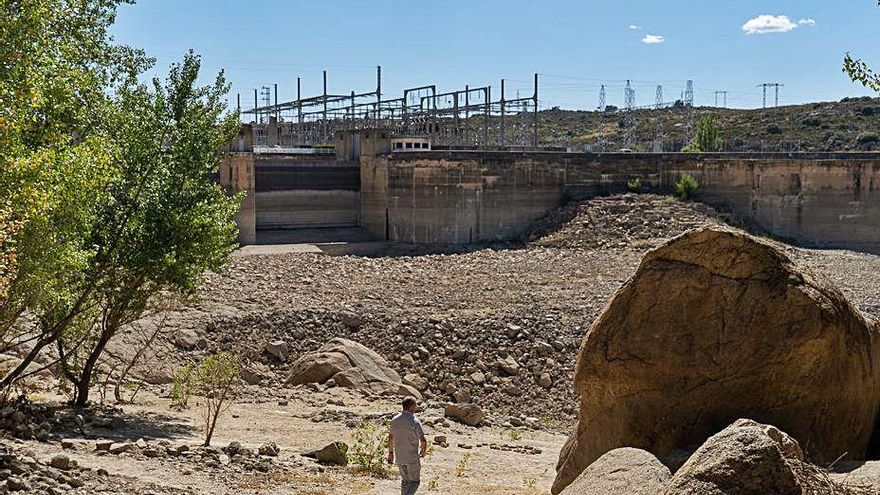 Un hombre camina por el embalse totalmente seco.