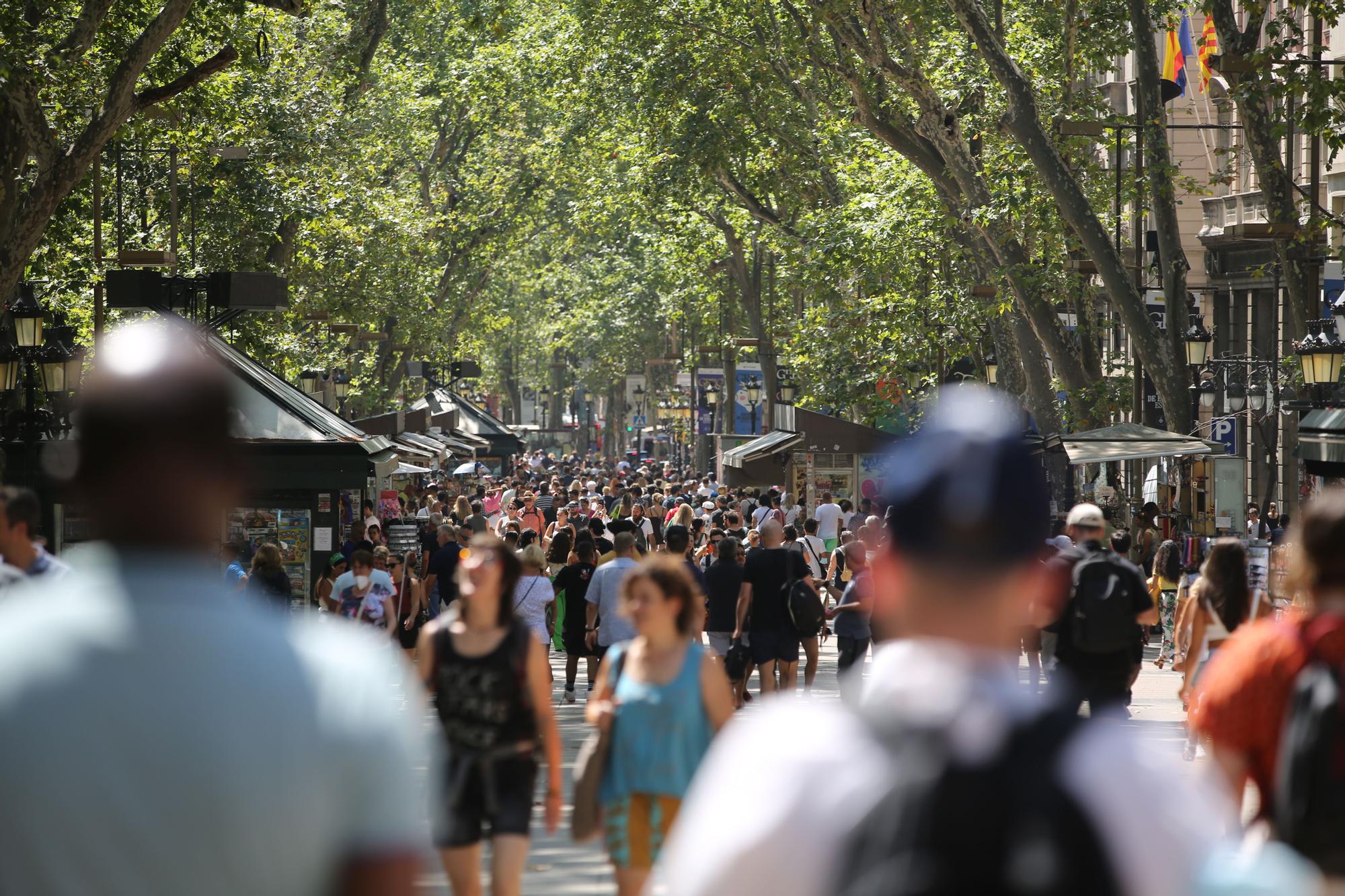 Decenas de personas pasean por la Rambla de Barcelona.