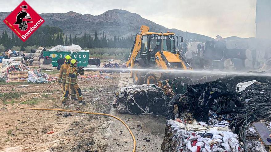 Tareas de extinción del incendio declarado este sábado en una fábrica textil de Alcosser.