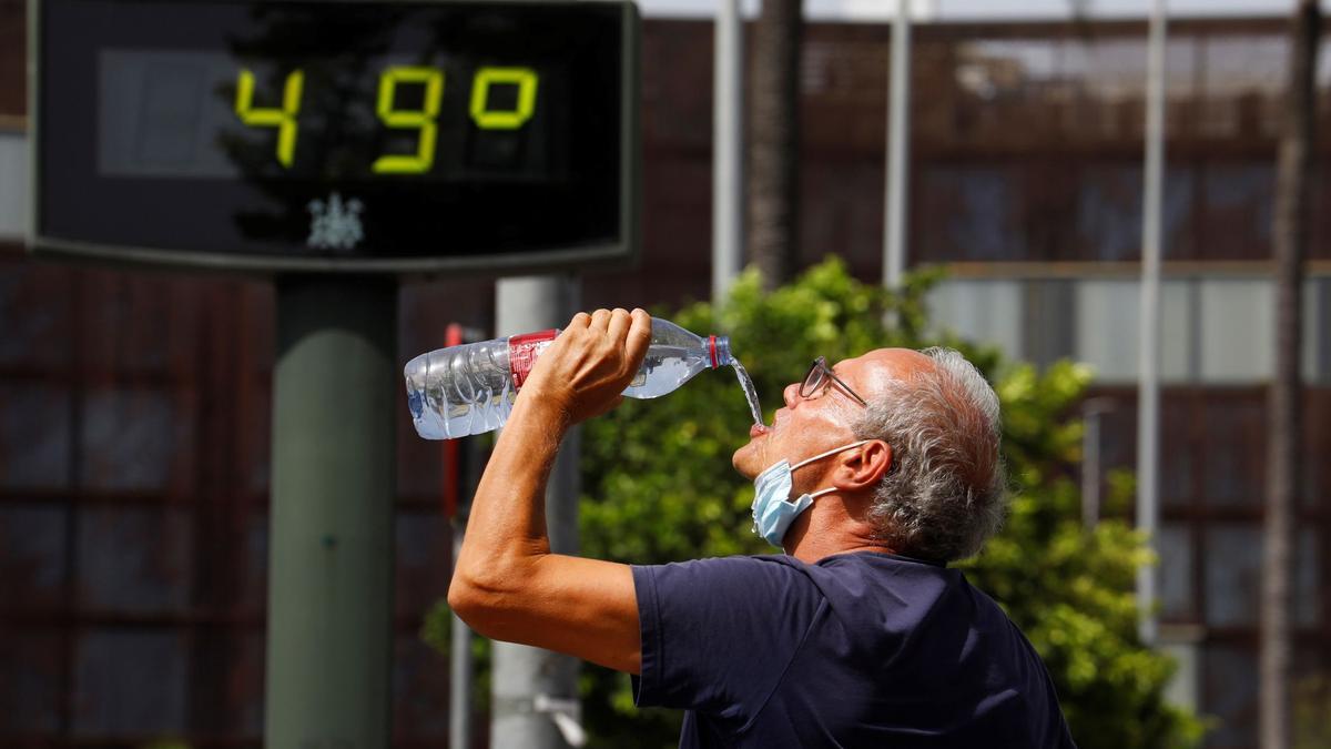 Un hombre bebe agua en Córdoba durante una ola de calor.