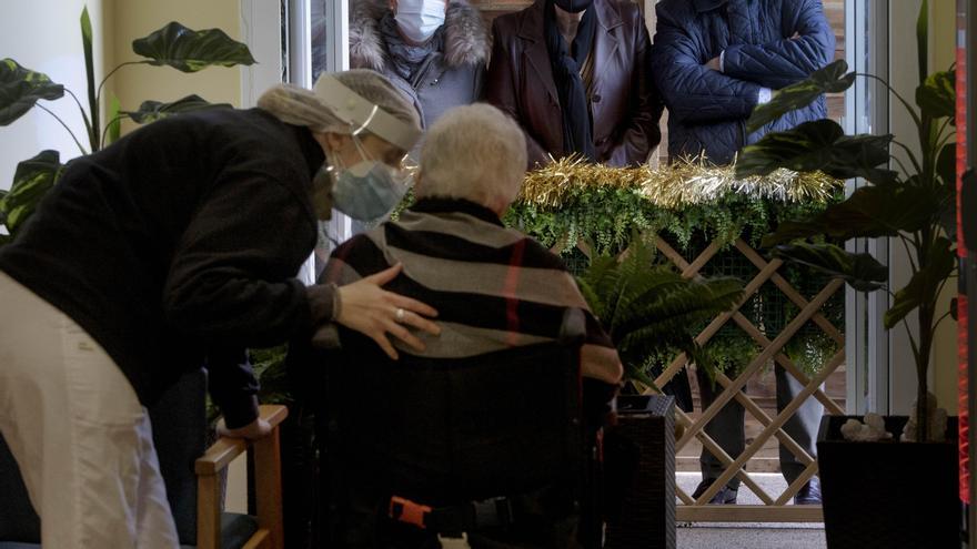 Visitas familiares a una residencia de El Puig con mascarillas y distancia social en una Navidad sin abrazos.