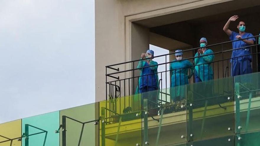 Profesionales sanitarios del Hospital Regional aplauden desde el balcón.