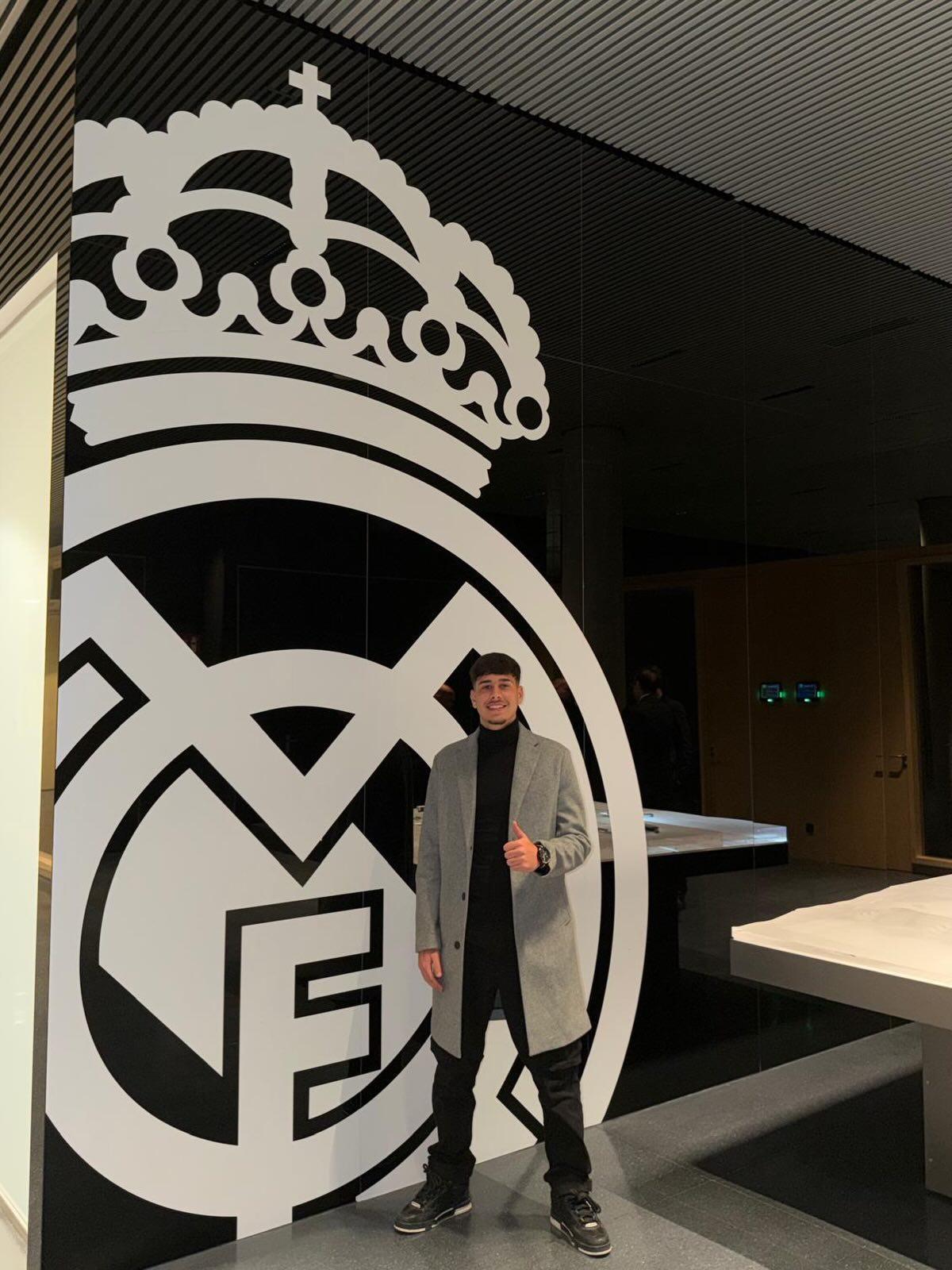 Alexis Ciria posa junto al escudo del Real Madrid en las instalaciones del club blanco.