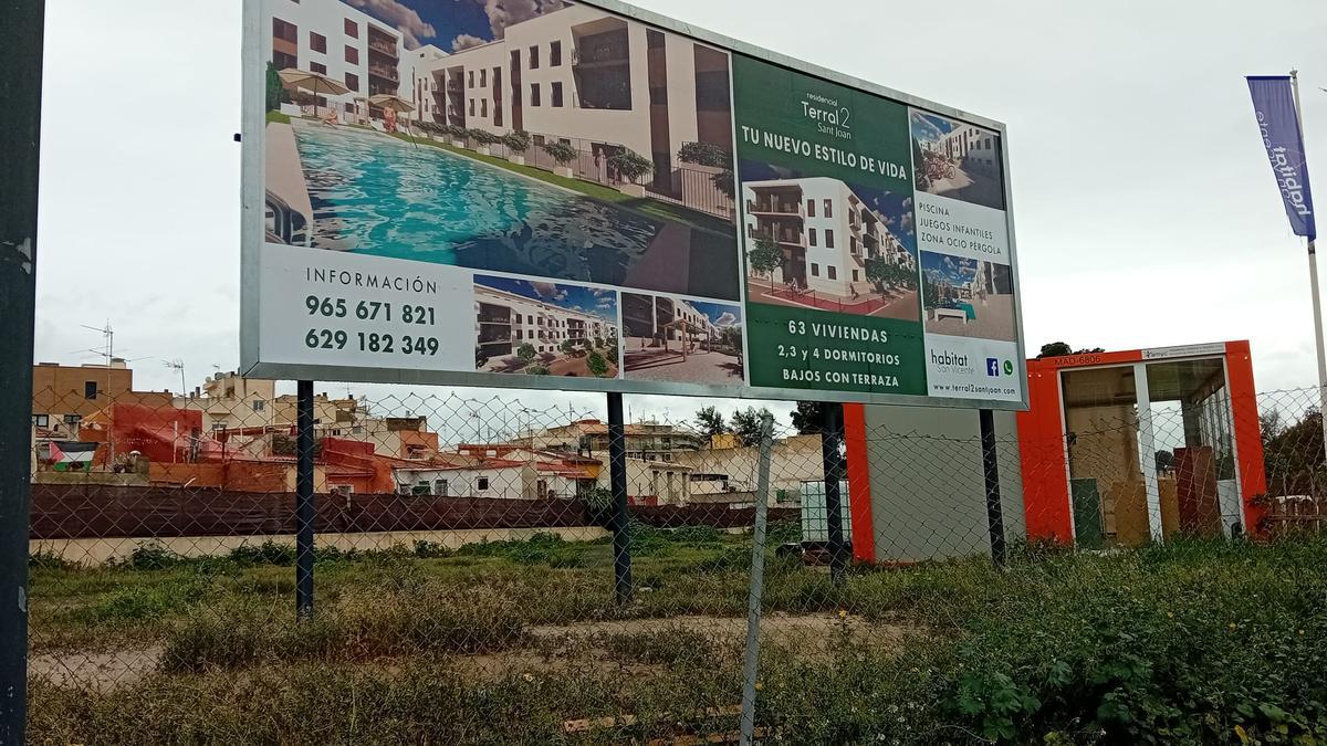 Publicidad de la promotora en el solar, con viviendas de la calle San José al fondo