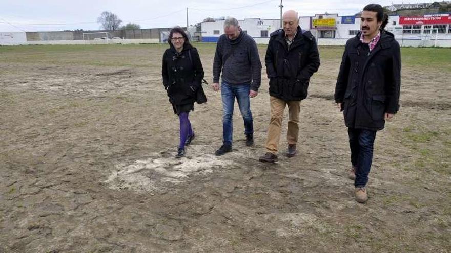 Mayi Colubi, Óscar Fernández y Andrés Fernández, de Podemos, con Ramón García, tercero por la izquierda, sobre el terreno de juego de Andés.