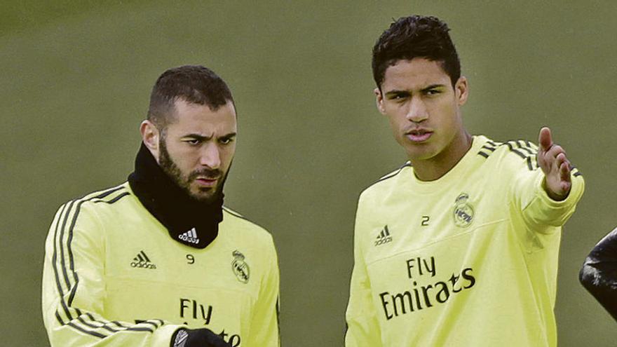 Benzema charla con Varane al inicio de un entrenamiento.