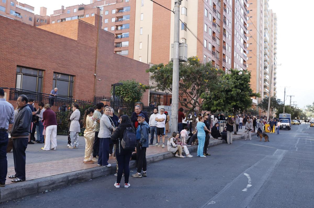Personas evacuan edificios tras un fuerte temblor este lunes, en Bogotá (Colombia).