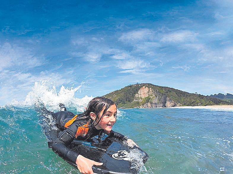 Una niña haciendo surf en Rodiles