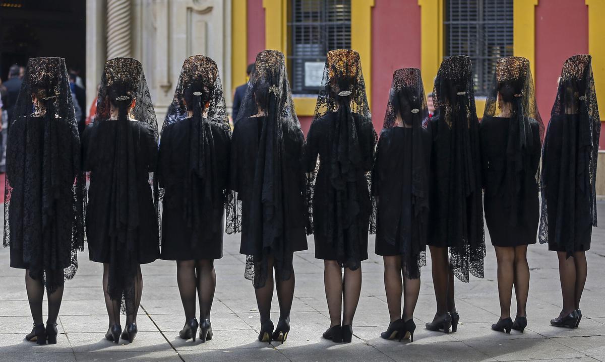 Mujeres vestidas de mantilla se dirigen a la Basílica de Nuestro Padre Jesús del Gran Poder