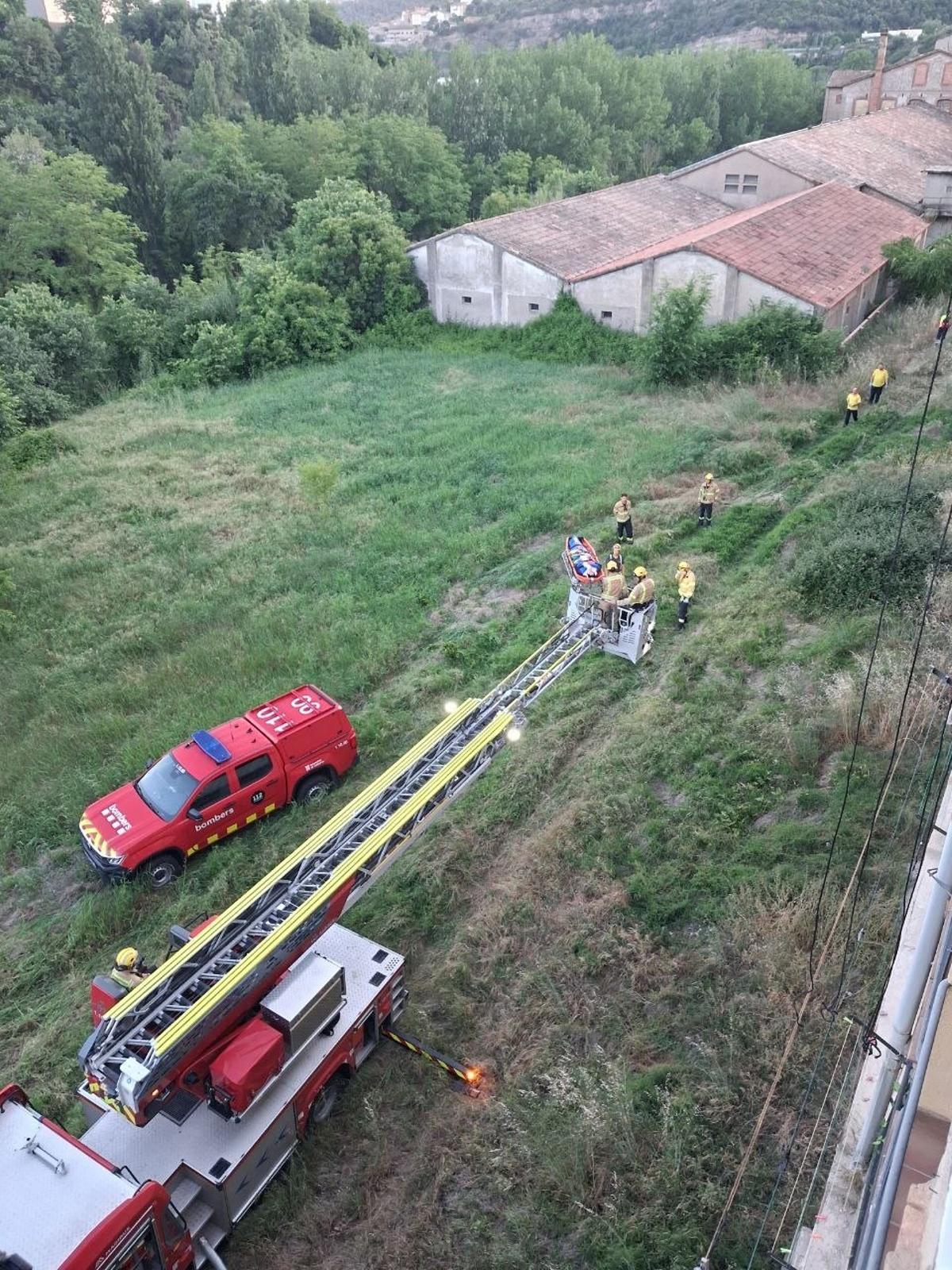Els Bombers baixant de casa la dona afectada