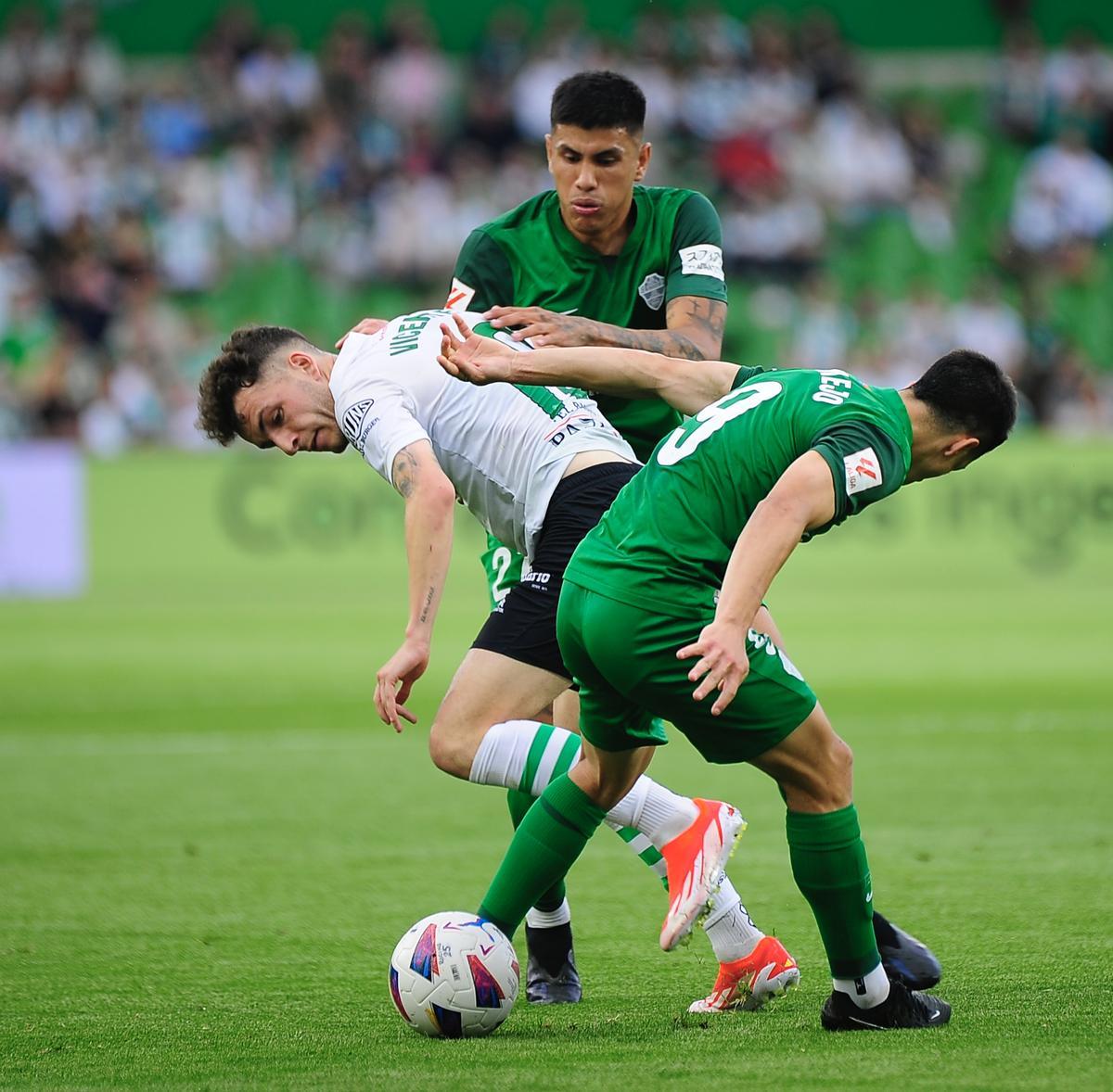 Bermejo y Nico Castro luchan por un balón con el jugador del Racing Íñigo Vicente