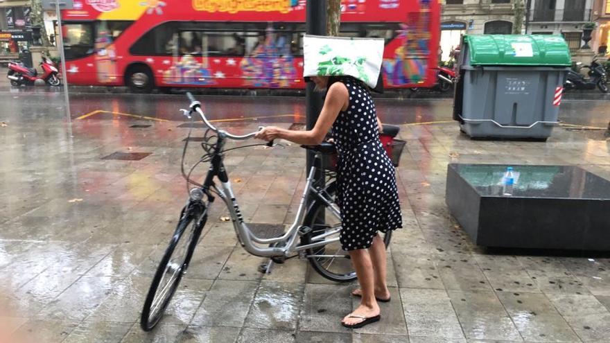 Una ciclista bajo la lluvia, este martes.