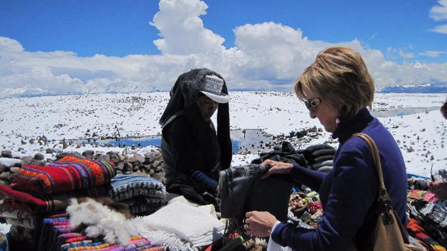 Turista española se interesa por la artesanía local en el altiplano andino.