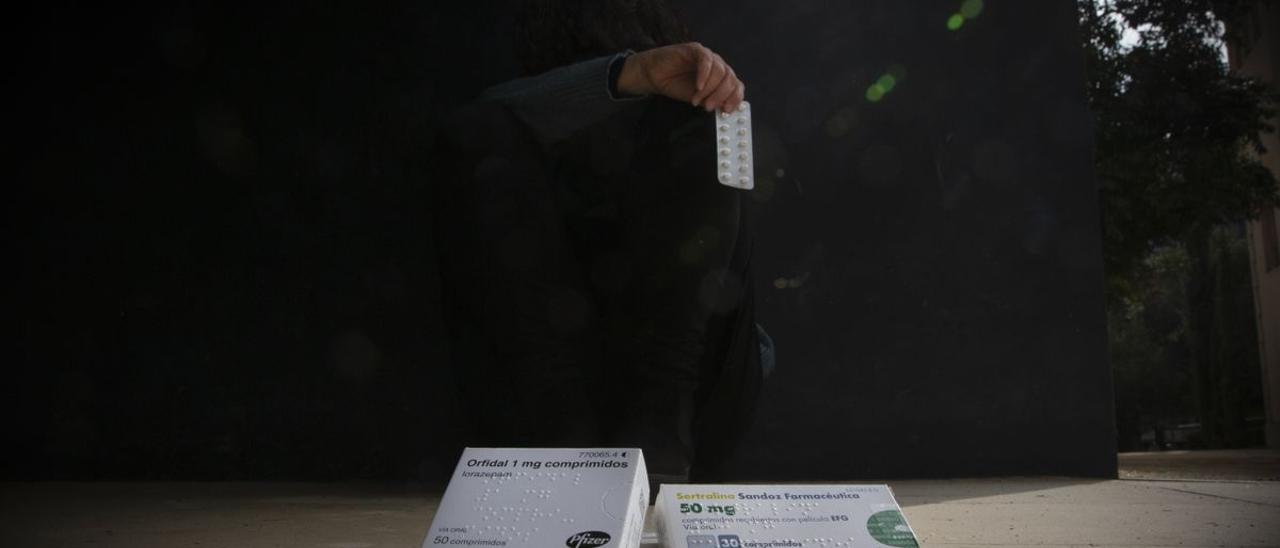 Una mujer sostiene en la mano algunos fármacos derivados de los opioides.