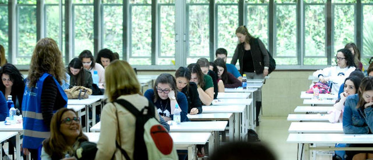 Dos enfermeras se desean suerte antes de entrar en un aula de Arquitectura para examinarse.