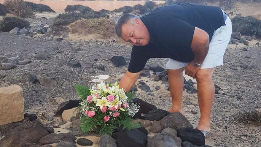 José Viera colocando un ramo de flores en la tumba de su hermana Carmen en el cementerio de Cofete, ayer.