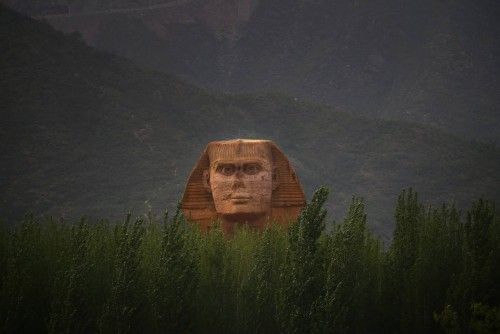 The head of a full-scale replica of the Sphinx, which is part of an unfinished theme park that will also accommodate the production of movies, television shows and animation, is seen behind trees on the outskirts of Shijiazhuang