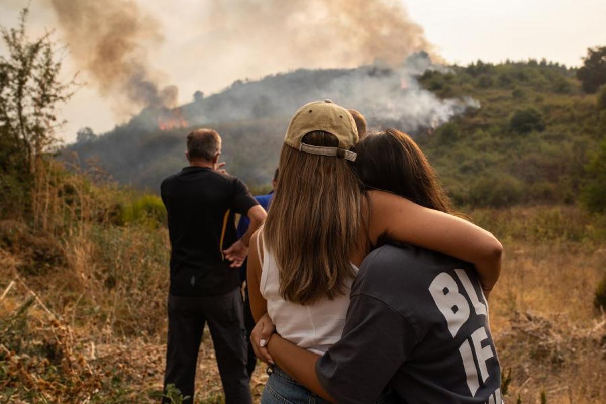 Vecinos de Molinaseca (León) observan el avance del fuego en su término en agoto de 2025.