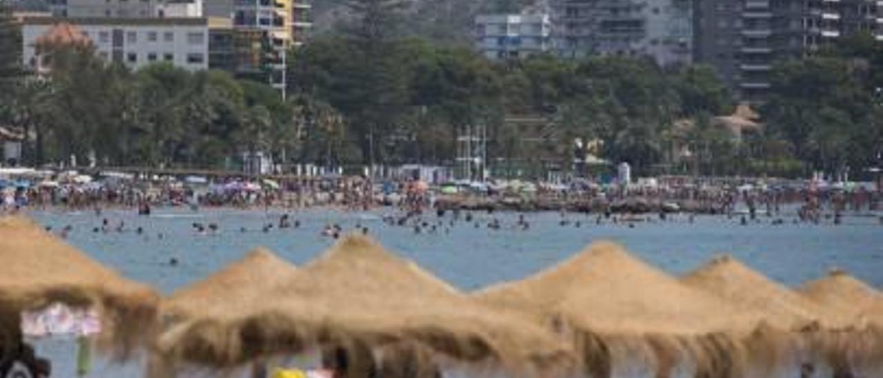 Una playa en la provincia de Castelló con edificios residenciales al fondo.