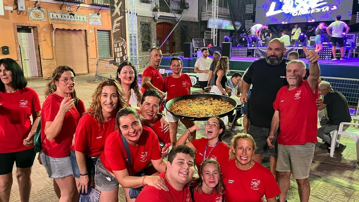Una colla mostrando su paella
