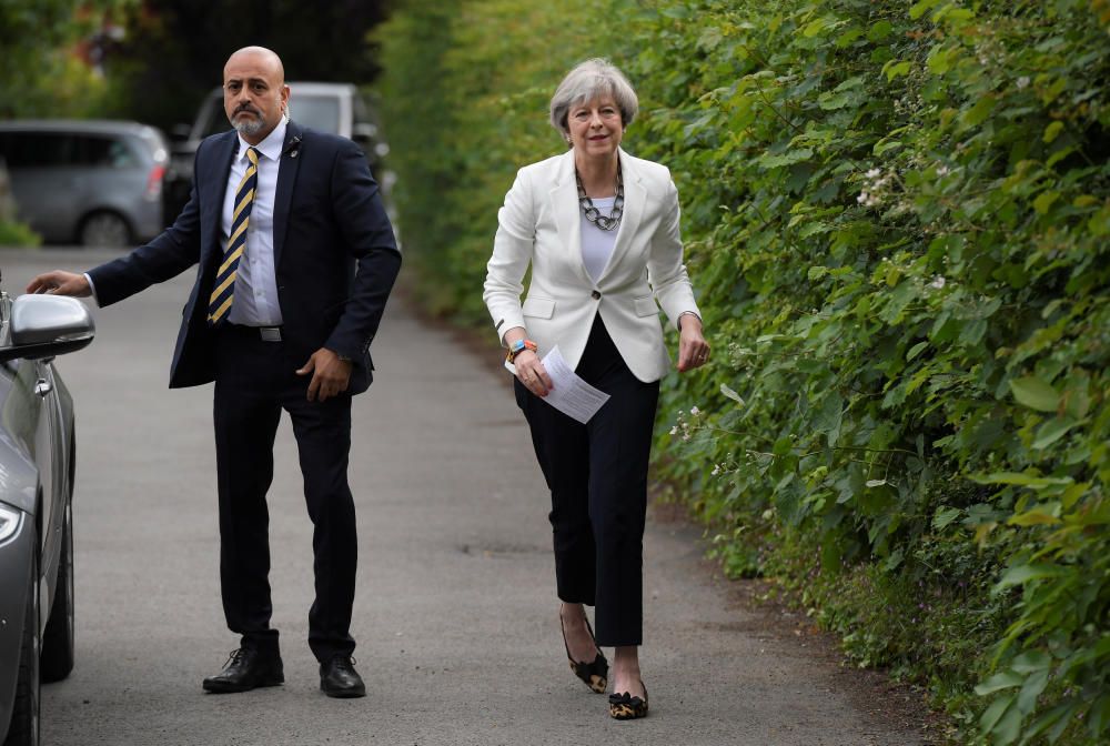 Theresa May sale de votar junto a su marido Philip.