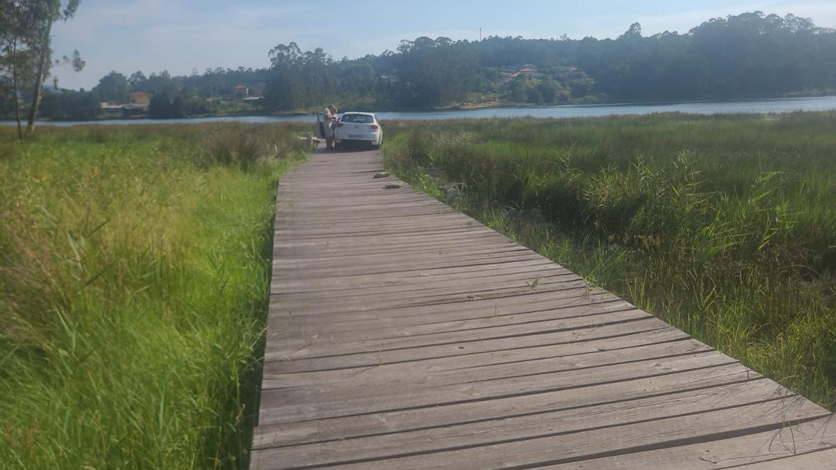 Imagen del coche accidentado, con el río Ulla al fondo.