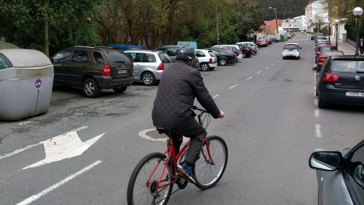 Un ciudadano circula con su bicicleta por el centro de Arteixo.