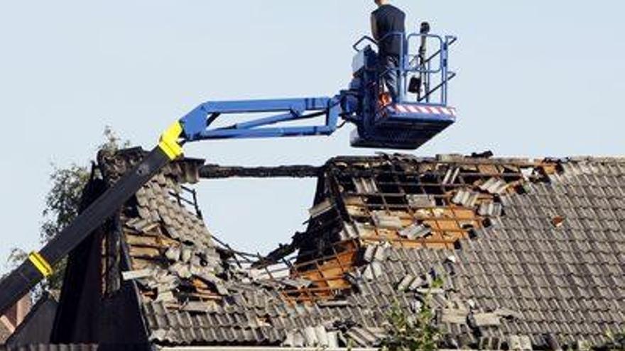 Un operario maneja una grúa sobre el tejado destruido de la casa donde han fallecido cuatro niños.