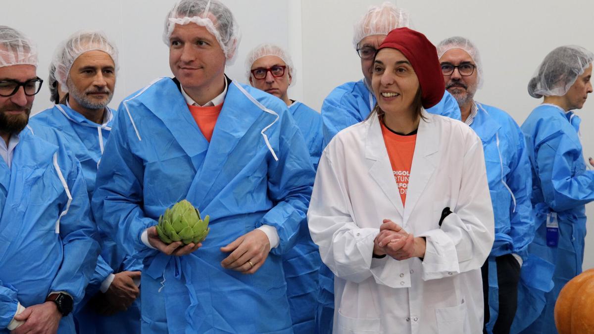 El conseller de Agricultura, Òscar Ordeig, junto a la presidenta de la Fundació Espigoladors, Mireia Barba, en las nuevas instalaciones de la empresa elaboradora És Im-Perfect, en El Prat de Llobregat.