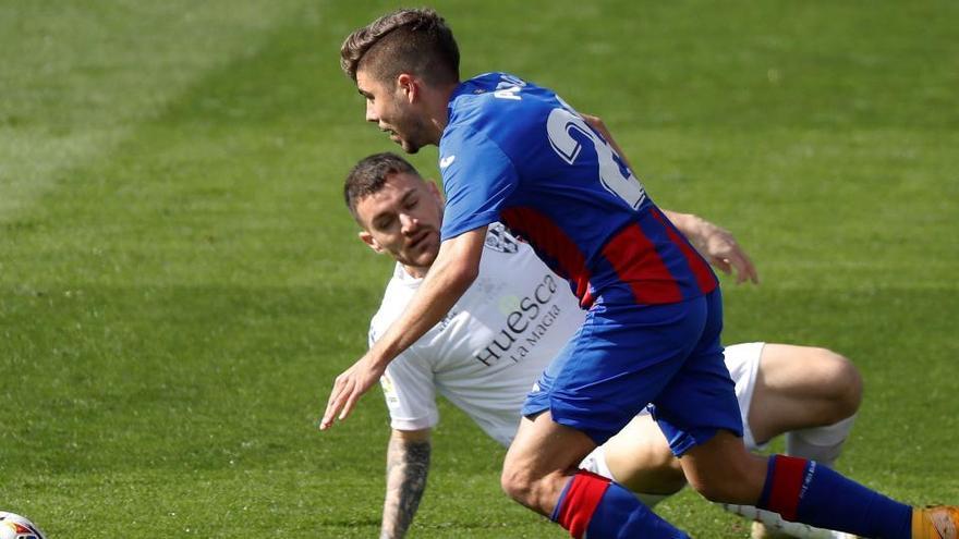 El delantero del Eibar Alejandro Pozo lucha un balón con el centrocampista Javier Galán, del Huesca