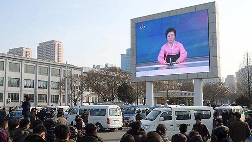 Varias personas observan una pantalla gigante en Pyongyang.