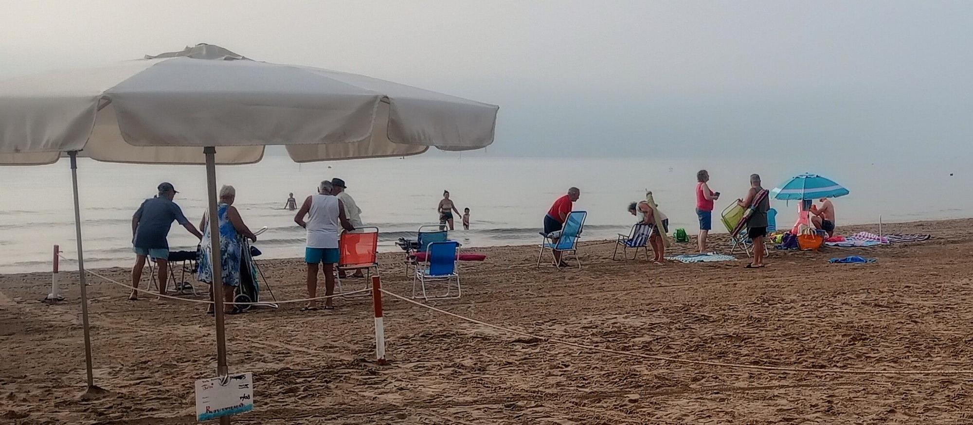 Bañistas a primera hora de la mañana en la playa de Cullera junto a la zona reservada para el alquiler.