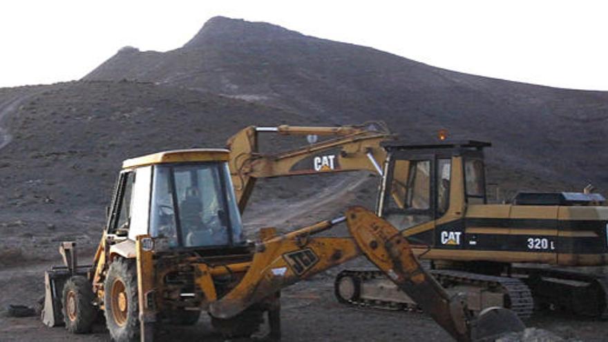 Las máquinas retroexcavadoras que iniciaron ayer el trabajo de arreglo del camino. Al fondo, la montaña de La Muda, ayer. i  GABRIEL FUSELLI