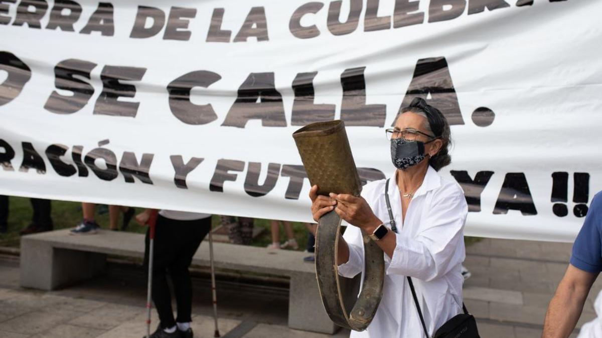 Una de las vecinas de la Sierra de La Culebra hace sonar un cencerro en la plaza de La Marina. 