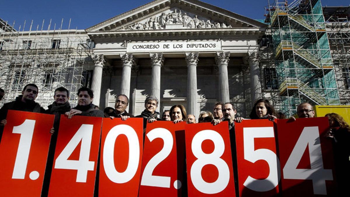 Miembros de la Plataforma de Afectados por la Hipoteca, con una pancarta con la cifra de firmas recogidas en favor de la dación en pago, el pasado 12 de febrero ante el Congreso.