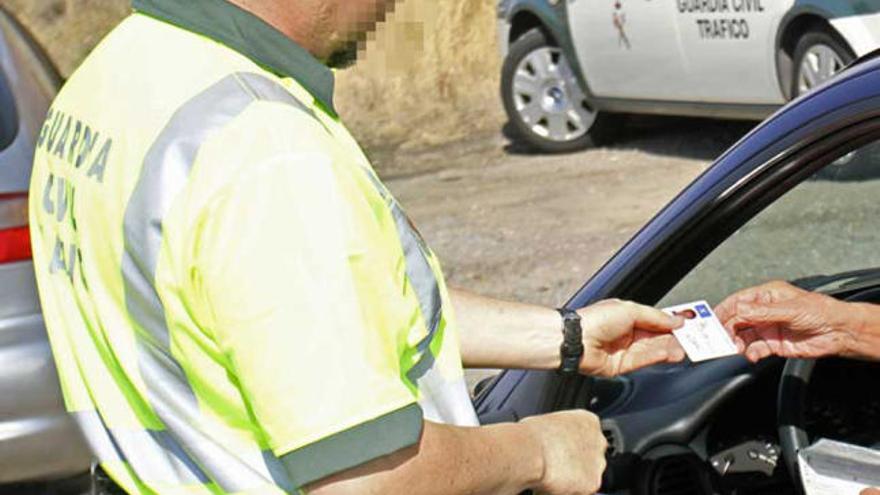 Un guardia civil pide documentación a un conductor.