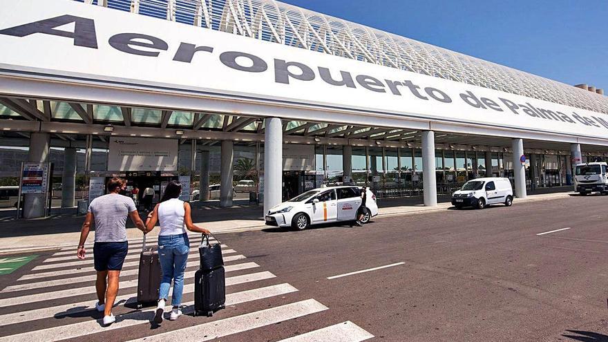 Dos turistas se dirigen a la terminal de salida del aeropuerto de Palma de Mallorca, ayer.