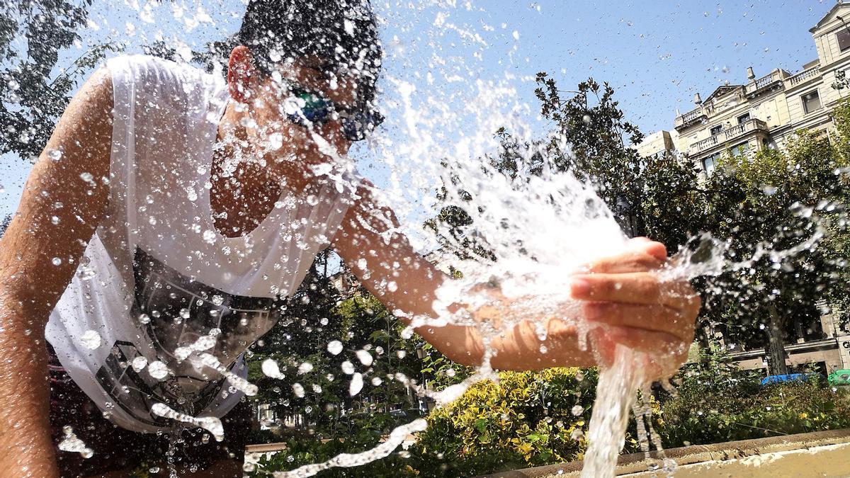 Un joven se refresca en la plaza de la Pau en Lleida