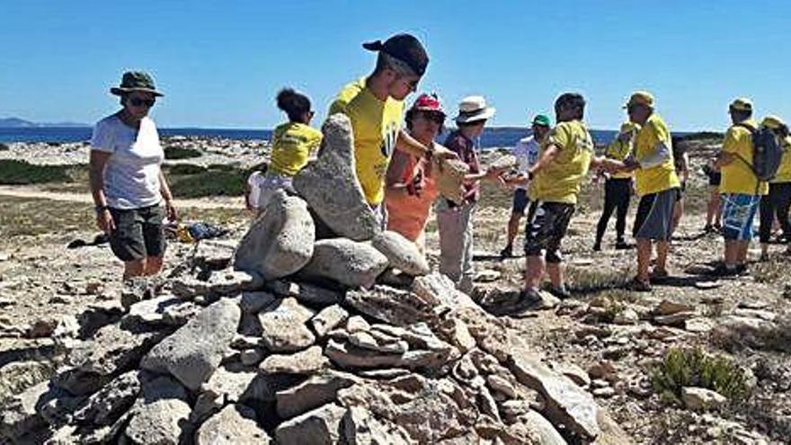 Un grupo de voluntarios retira piedras apiladas en es Pas des Trucadors.