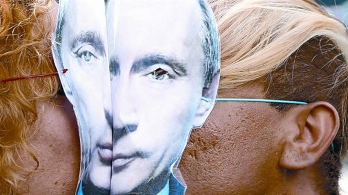 Una pareja, con caretas de Vladimir Putin, se besa durante la protesta contra la discriminación sexual realizada el pasado domingo en París.