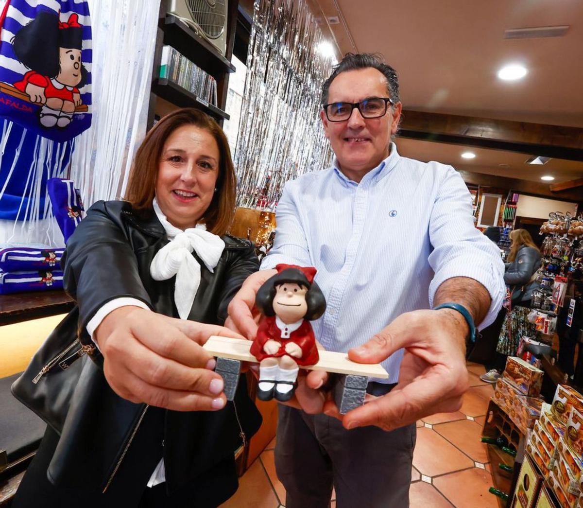 Noelia González y Guillermo Bernardo, con una réplica de Mafalda, en su tienda de Oviedo. | | D. C.