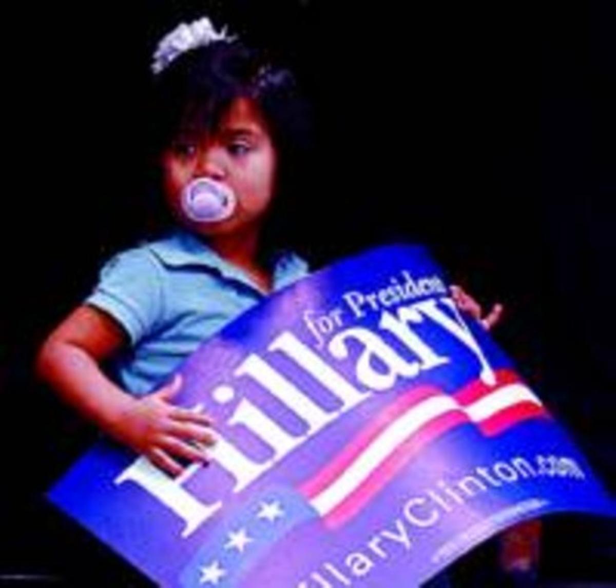 Una nena sosté un cartell de suport a Clinton en un míting a Texas.