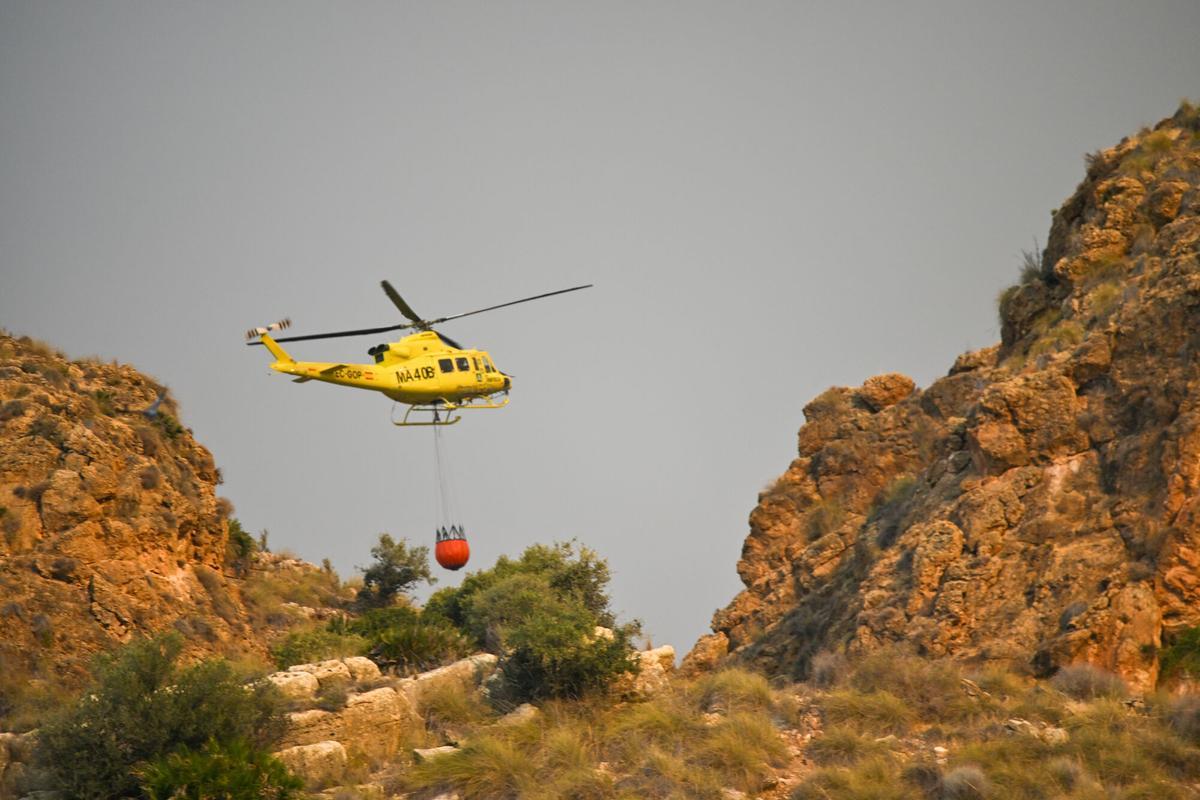 Un helicóptero trabaja este viernes en las labores de extinción del incendio forestal declarado en Los Gallardos, Almería.