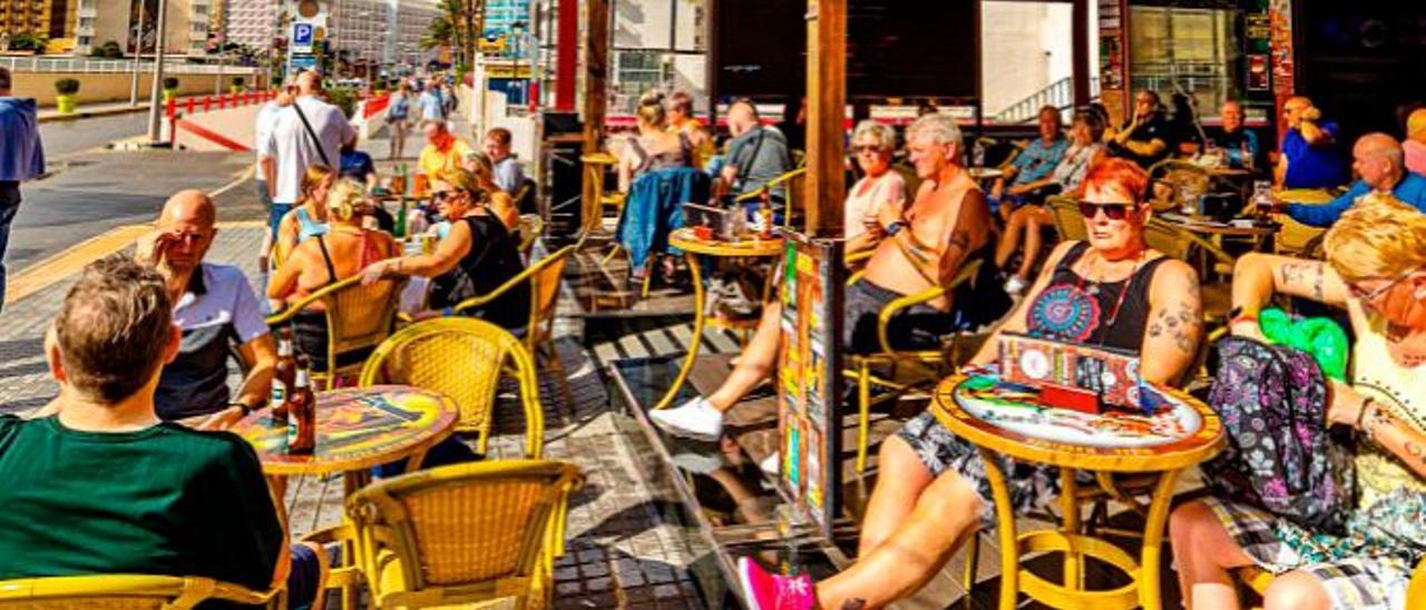 Turistas tomaban el sol en una terraza de un pub, ayer, en Benidorm. | DAVID REVENGA